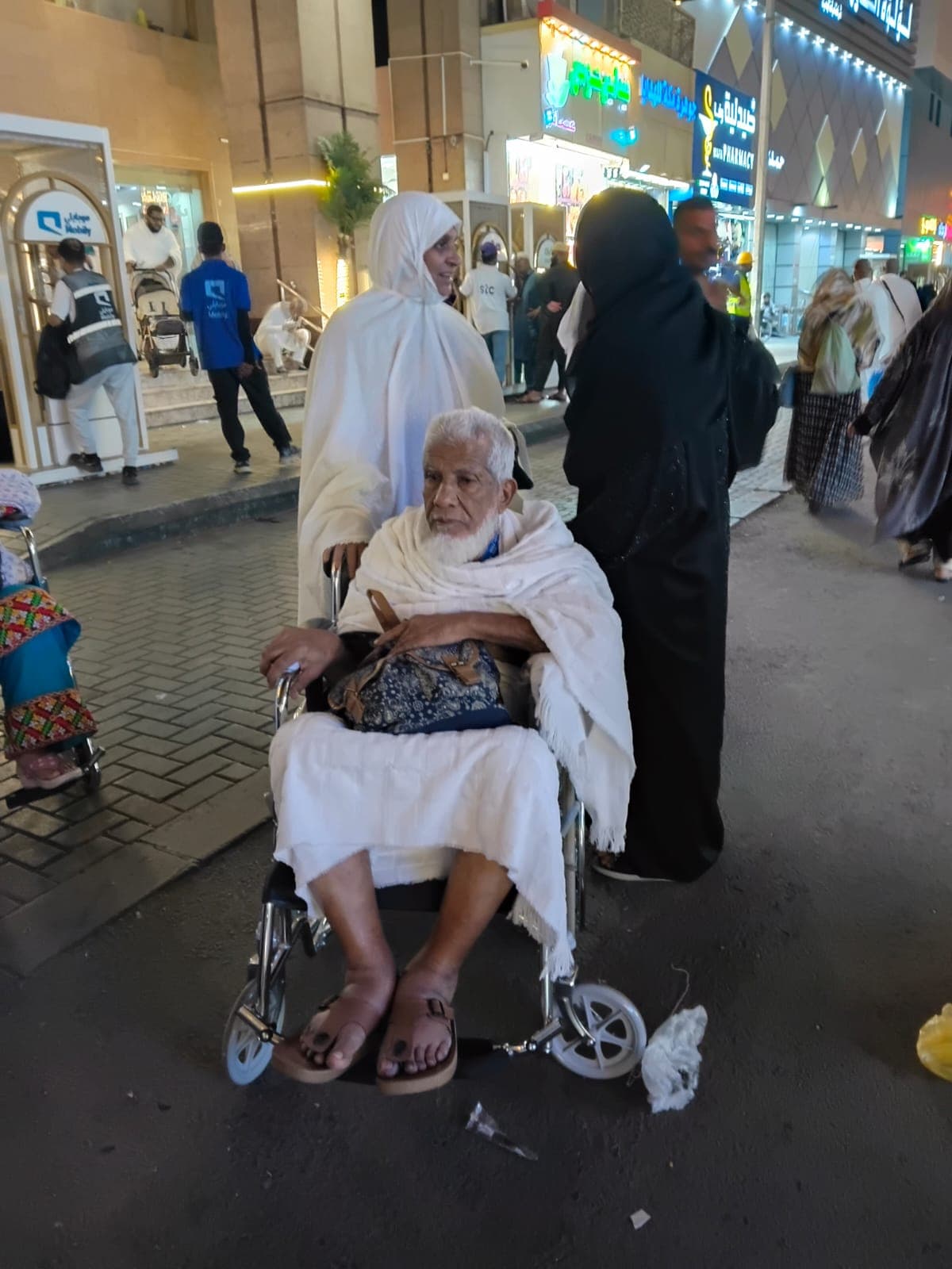 Wheelchair assistance for an elderly pilgrim in ihram near the Haram, Makkah, August 2026 Umrah