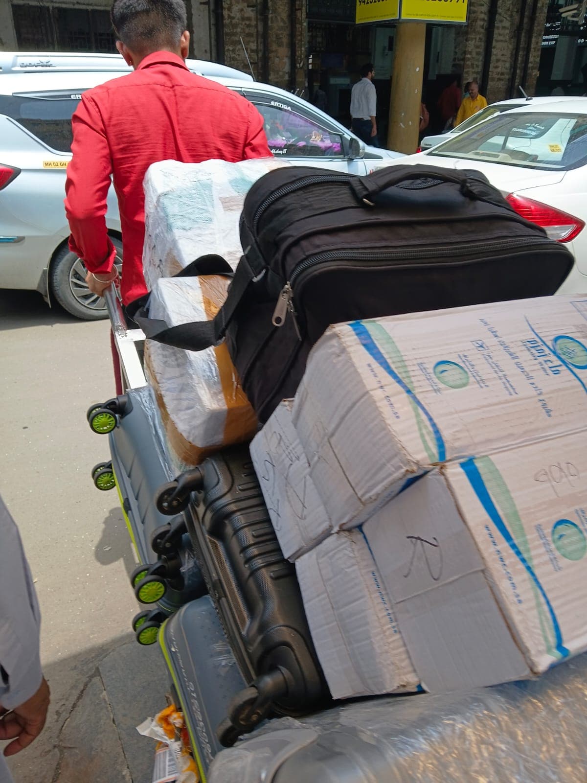 Back in Mumbai, our helper carries pilgrims' Zamzam cartons and luggage after the August 2026 Umrah